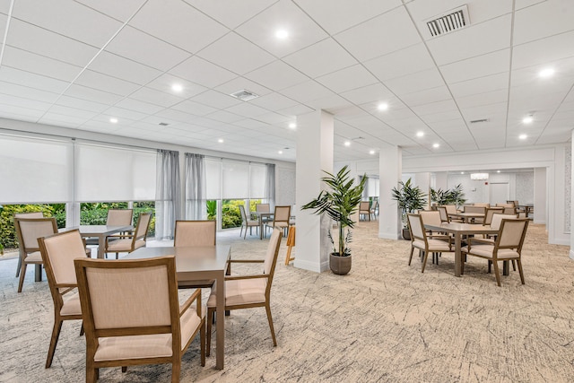 carpeted dining room featuring a paneled ceiling