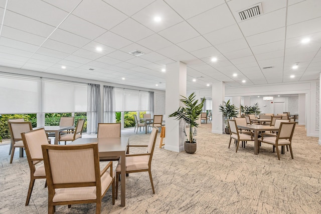 dining space featuring light colored carpet, visible vents, and a paneled ceiling