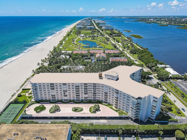 birds eye view of property with a water view and a beach view