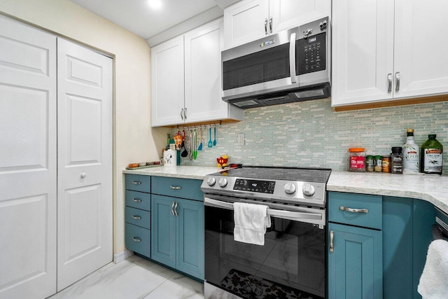 kitchen featuring stainless steel appliances, light tile patterned floors, decorative backsplash, white cabinetry, and blue cabinetry