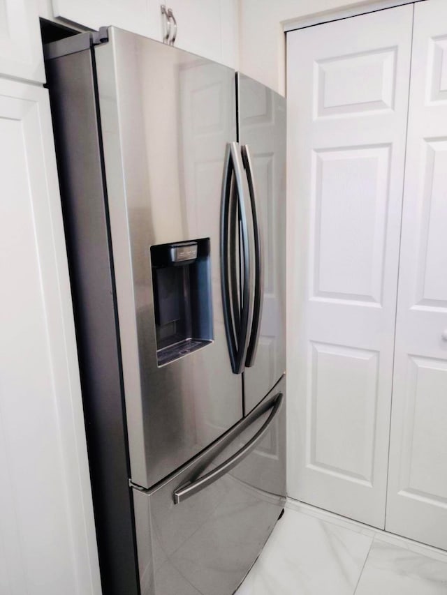 kitchen featuring white cabinetry and stainless steel refrigerator with ice dispenser