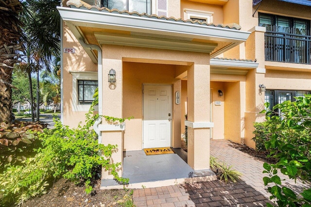 view of exterior entry featuring a balcony