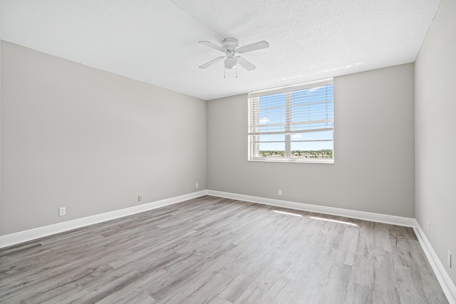 unfurnished room with a textured ceiling, ceiling fan, and light hardwood / wood-style flooring