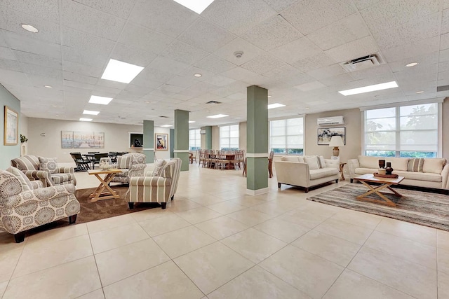 tiled living room with a wall mounted air conditioner and a drop ceiling