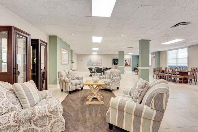 tiled living room featuring a drop ceiling