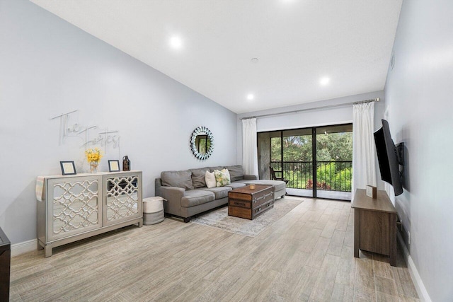 living room featuring light hardwood / wood-style floors and vaulted ceiling