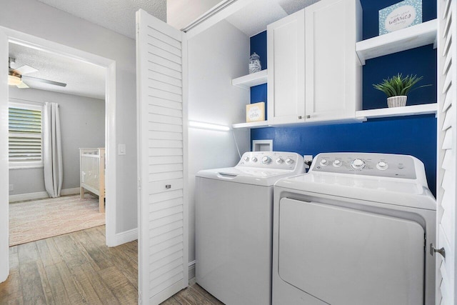 laundry room featuring ceiling fan, washer and dryer, cabinets, a textured ceiling, and light hardwood / wood-style flooring