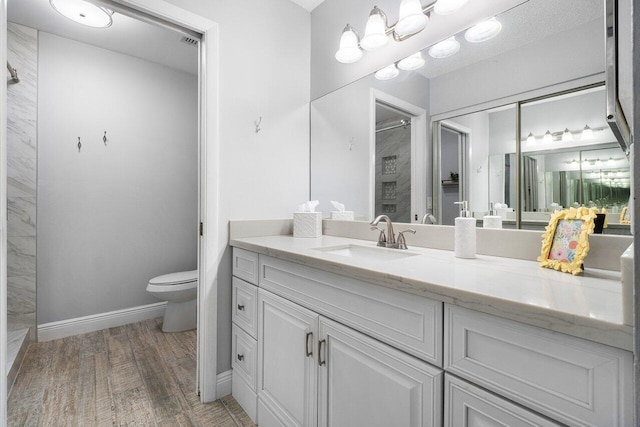 bathroom featuring hardwood / wood-style flooring, toilet, and vanity