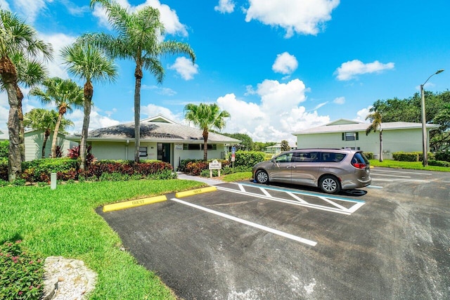 view of vehicle parking with a lawn