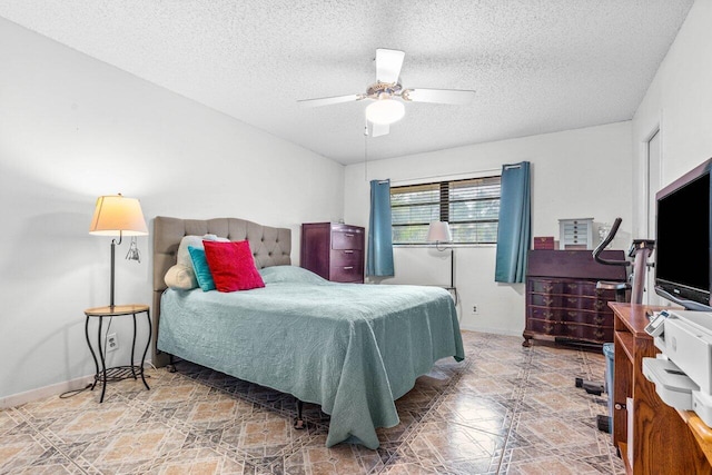 bedroom featuring tile patterned floors, ceiling fan, and a textured ceiling