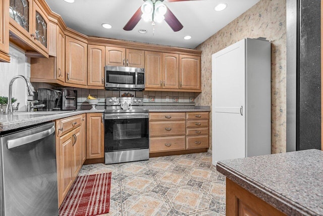 kitchen featuring light tile patterned floors, stainless steel appliances, sink, ceiling fan, and decorative backsplash