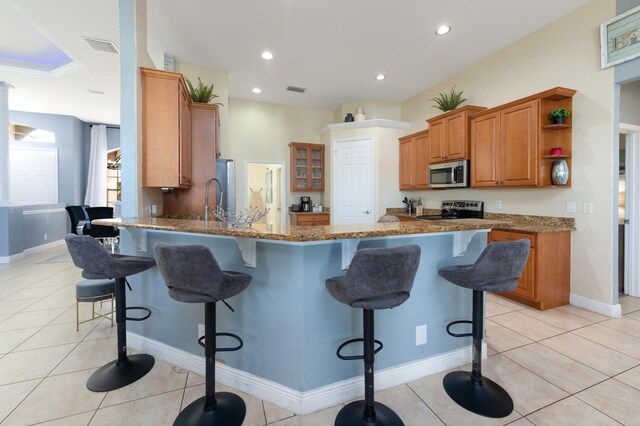 kitchen featuring light tile patterned flooring, kitchen peninsula, and stove