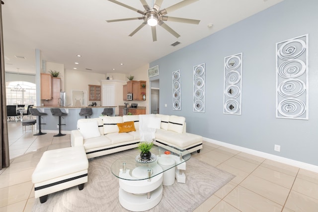 living room featuring light tile patterned floors, a ceiling fan, and baseboards