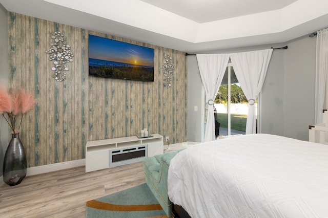 bedroom with access to outside, wood finished floors, and baseboards