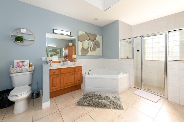 full bathroom featuring vanity, toilet, tile patterned floors, and independent shower and bath