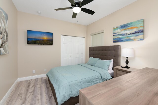 bedroom featuring ceiling fan, light hardwood / wood-style floors, and a closet