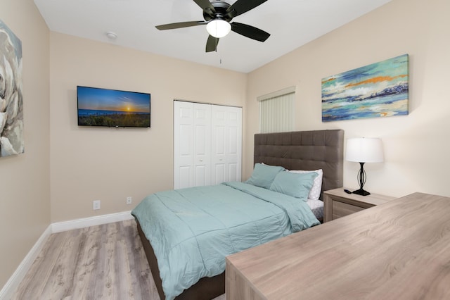 bedroom featuring a ceiling fan, wood finished floors, baseboards, and a closet