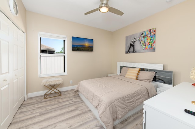 bedroom featuring a ceiling fan, light wood-style flooring, baseboards, and a closet