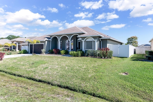 mediterranean / spanish house featuring stucco siding, driveway, a garage, and fence