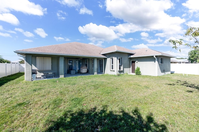 back of house featuring a patio area, a fenced backyard, a lawn, and stucco siding