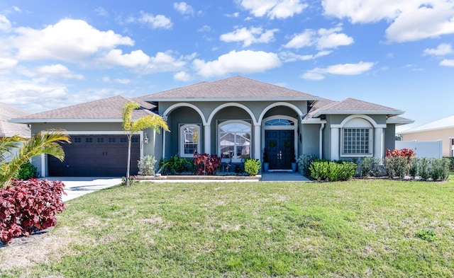 mediterranean / spanish-style home featuring a garage and a front lawn