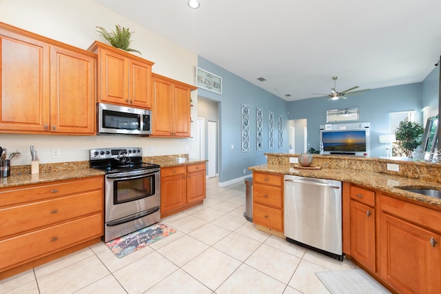 kitchen featuring light tile patterned floors, stainless steel appliances, ceiling fan, and light stone countertops