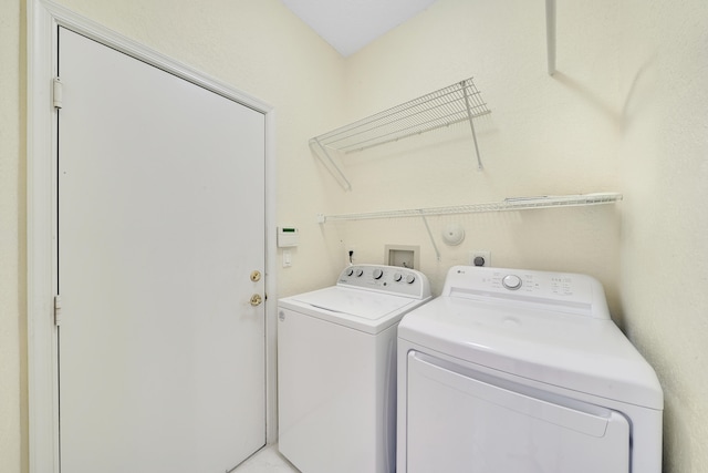 clothes washing area featuring separate washer and dryer