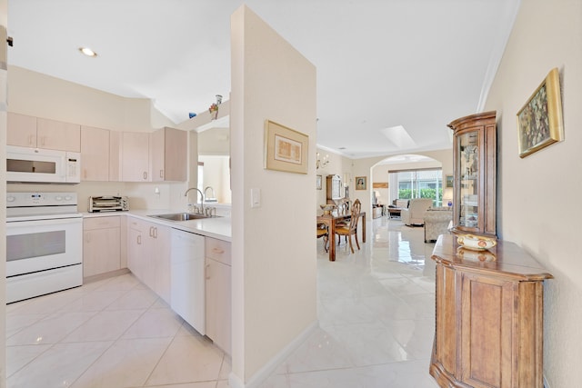 kitchen with sink, crown molding, white appliances, and light tile patterned floors