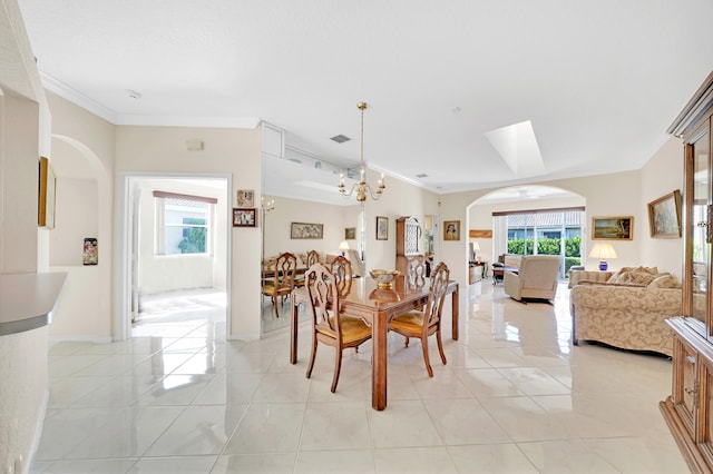 tiled dining space with crown molding and a chandelier