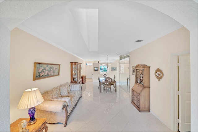 living room with a notable chandelier, ornamental molding, and light tile patterned floors