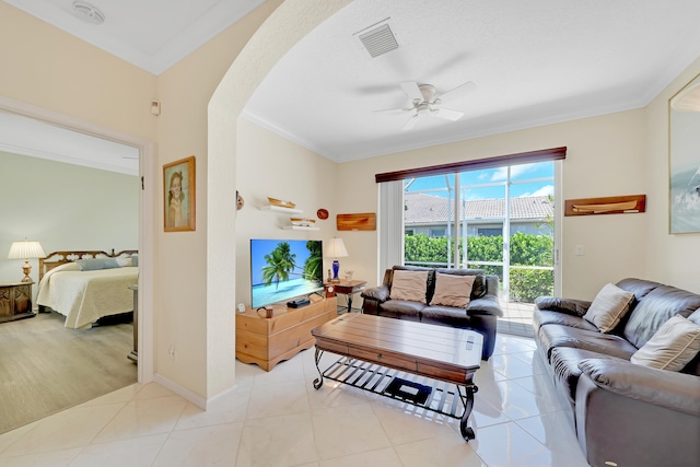 tiled living room with ceiling fan and ornamental molding