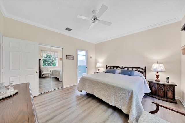 bedroom featuring a closet, ceiling fan, ornamental molding, and light wood-type flooring