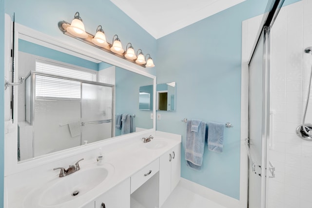 bathroom with double vanity and a shower with door