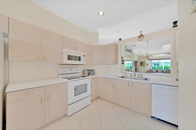 kitchen with light tile patterned flooring, an inviting chandelier, decorative light fixtures, white appliances, and light brown cabinetry