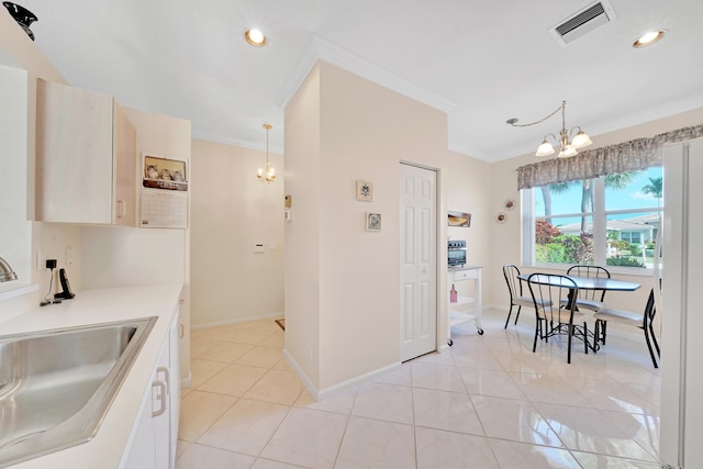 kitchen featuring a chandelier, hanging light fixtures, light tile patterned floors, sink, and crown molding