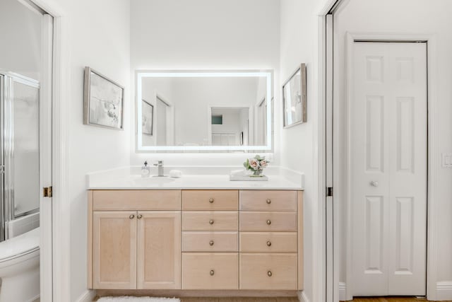 full bathroom featuring vanity, toilet, and enclosed tub / shower combo