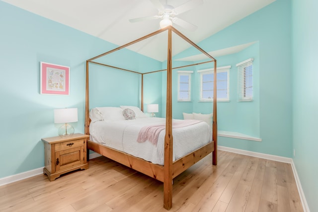 bedroom with ceiling fan, lofted ceiling, and light wood-type flooring