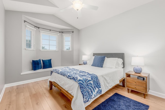 bedroom featuring lofted ceiling, a ceiling fan, baseboards, and wood finished floors