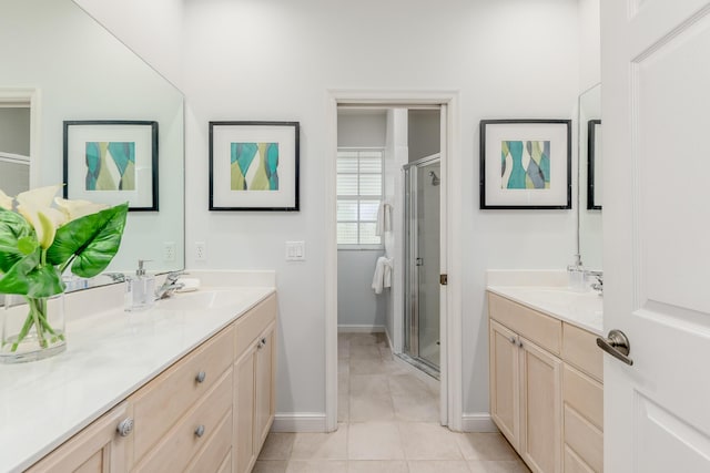 full bathroom with a stall shower, tile patterned floors, baseboards, and vanity