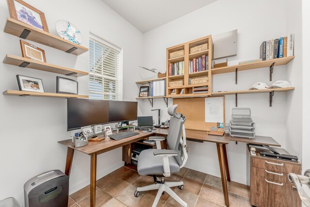 home office featuring light tile patterned floors and baseboards