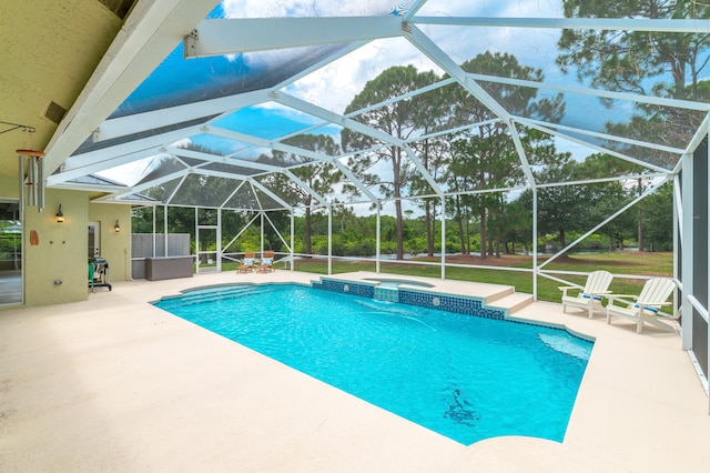 view of pool featuring an in ground hot tub, glass enclosure, and a patio area