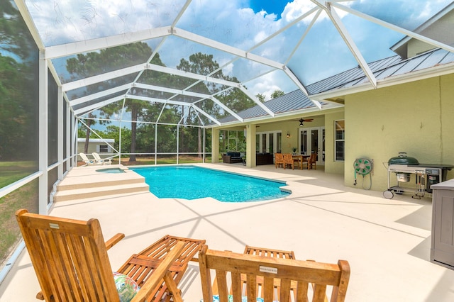 outdoor pool featuring a patio, a ceiling fan, outdoor dining space, glass enclosure, and an in ground hot tub