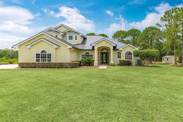 view of front of property featuring a front yard and a storage shed