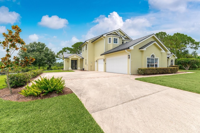 traditional-style house featuring concrete driveway, metal roof, a standing seam roof, a front lawn, and stucco siding