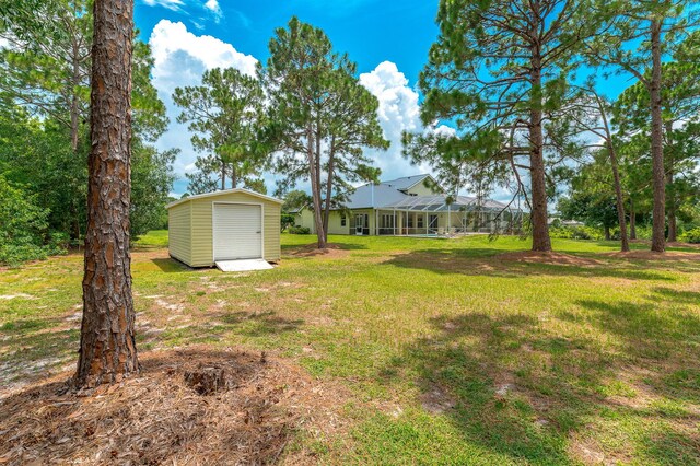 view of yard with an outbuilding, a lanai, and a storage unit