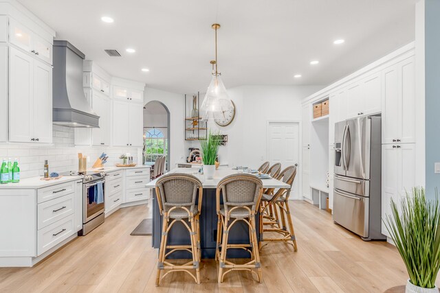 kitchen featuring glass insert cabinets, light countertops, white cabinets, and premium range hood