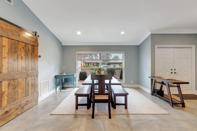 tiled dining room with crown molding and a barn door