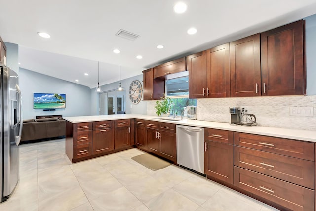 kitchen featuring vaulted ceiling, decorative light fixtures, sink, kitchen peninsula, and stainless steel appliances