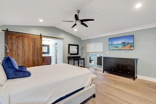 bedroom featuring vaulted ceiling, a barn door, ceiling fan, and light hardwood / wood-style flooring