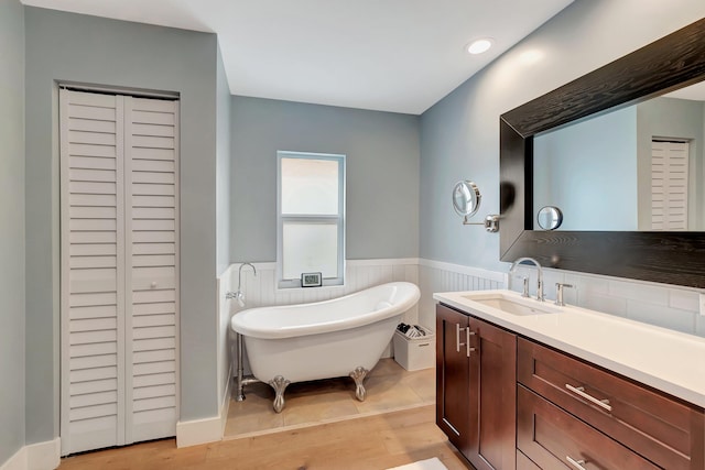 bathroom featuring vanity, a tub to relax in, and hardwood / wood-style flooring